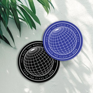 May include: Two round stickers with a globe design and the text "You make the world a better place from the class of 2024". One sticker is black with a white globe and the other is blue with a white globe.