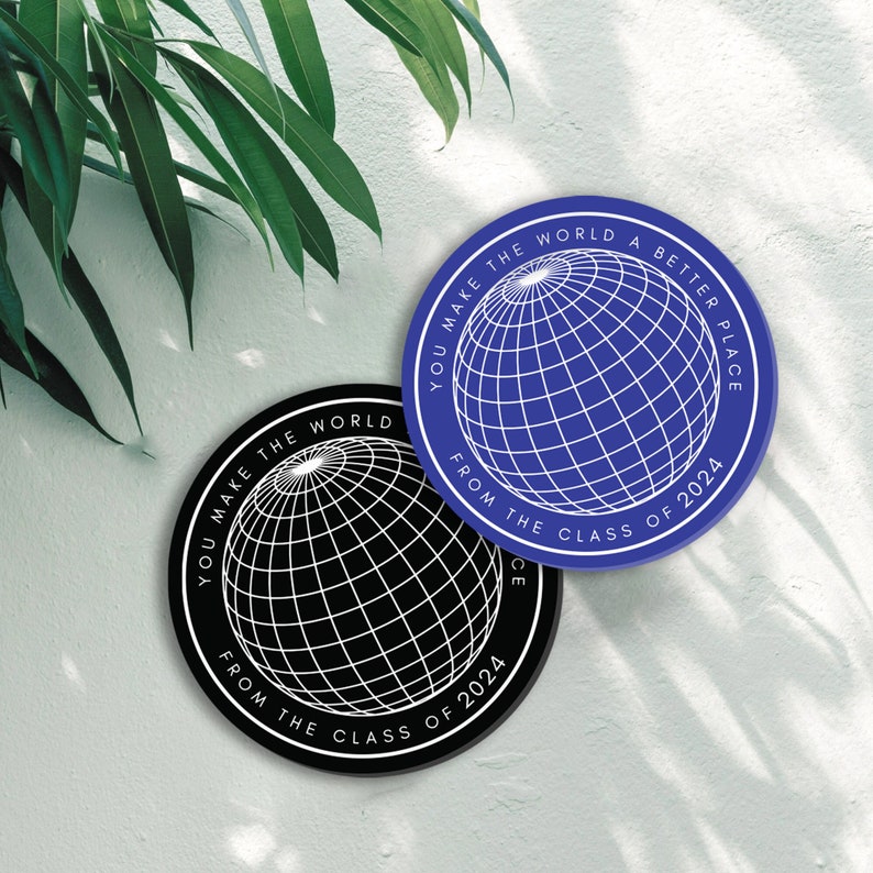 May include: Two round stickers with a globe design and the text "You make the world a better place from the class of 2024". One sticker is black with a white globe and the other is blue with a white globe.