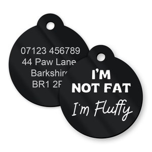May include: Two black round dog tags with white text. The first tag has a phone number, address, and postcode. The second tag says "I'm not fat I'm fluffy".