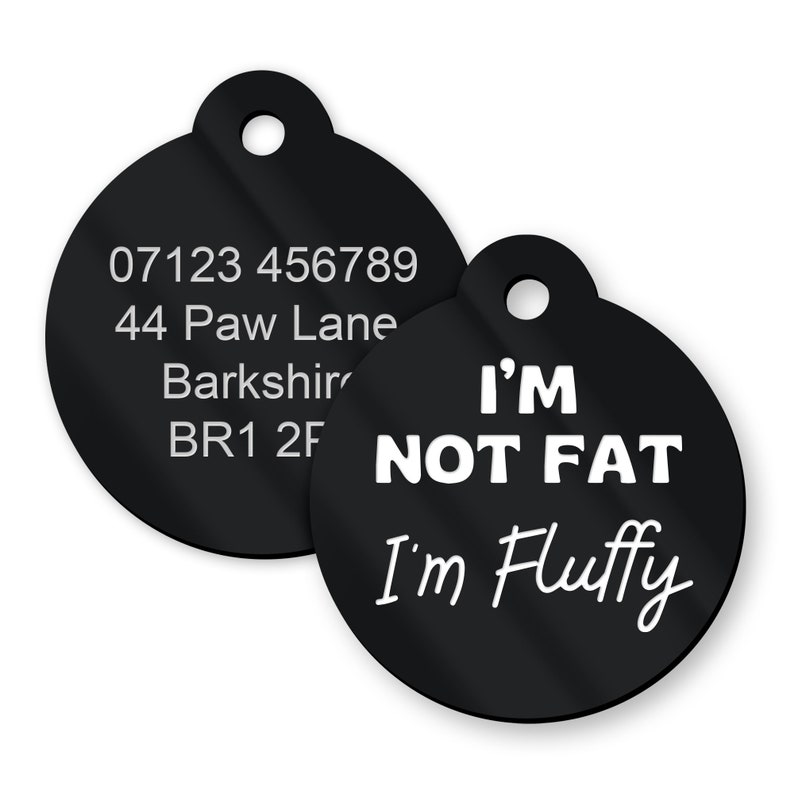 May include: Two black round dog tags with white text. The first tag has a phone number, address, and postcode. The second tag says "I'm not fat I'm fluffy".