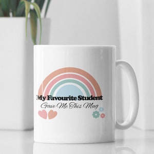 May include: White ceramic mug with a rainbow design and the text "My Favourite Student Gave Me This Mug".
