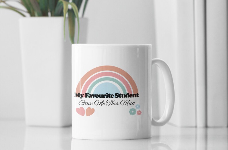 May include: White ceramic mug with a rainbow design and the text "My Favourite Student Gave Me This Mug".