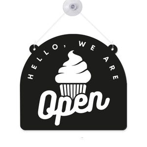 Może przedstawiać: Czarno-biały wiszący znak z napisem "Hello, We Are Open" i grafiką babeczki. Znak jest przymocowany do białej przyssawki ze sznurkiem.