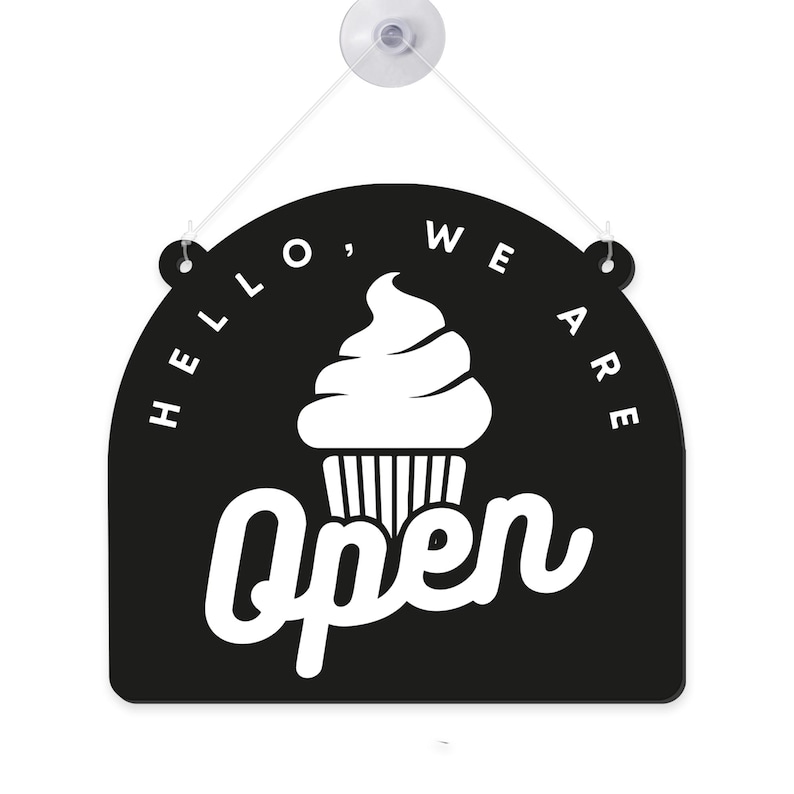 Może przedstawiać: Czarno-biały wiszący znak z napisem "Hello, We Are Open" i grafiką babeczki. Znak jest przymocowany do białej przyssawki ze sznurkiem.