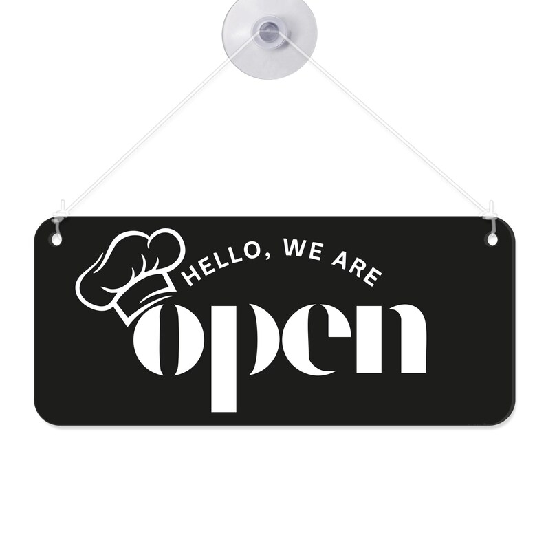 Peut inclure: Panneau rectangulaire noir avec texte blanc et un graphisme de toque de chef. Le panneau indique "Hello, we are open" en gras, police sans-serif. Une ventouse et une ficelle sont attach&eacute;es pour l'accrocher.
