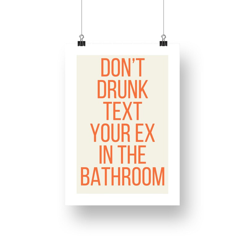 Op de afbeelding: Een witte poster met de tekst "DON'T DRUNK TEXT YOUR EX IN THE BATHROOM" in oranje letters op een beige achtergrond.