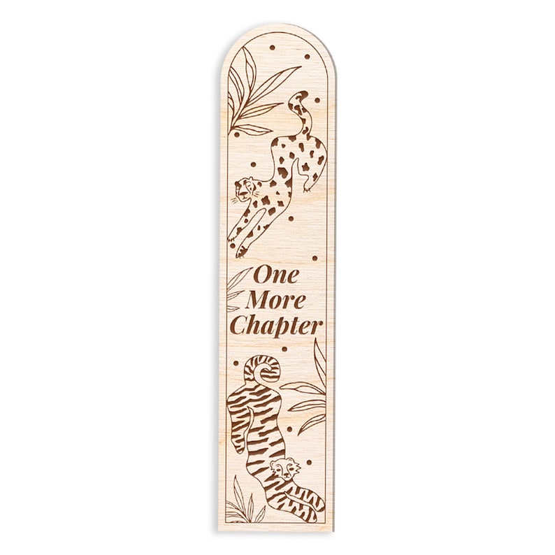 Op de afbeelding: Houten bladwijzer in lichtbruin met gravures. Het ontwerp toont illustraties van luipaarden en bladeren, met de tekst "One More Chapter". Het ontwerp omvat een springende luipaard en een met een welp. De vorm is rechthoekig met een afgeronde bovenkant.