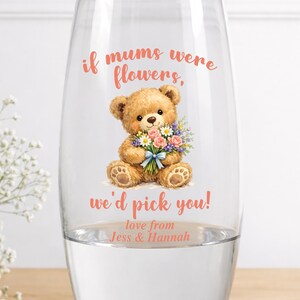 May include: A clear glass vase with a teddy bear illustration holding a bouquet of flowers. The text on the vase reads "if mums were flowers, we'd pick you!" and "love from Jess & Hannah".