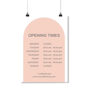 May include: A poster with the text "OPENING TIMES" in a coffee shop. The poster has a peach-colored arch shape with the shop's hours listed for each day of the week, including the phone number and website.