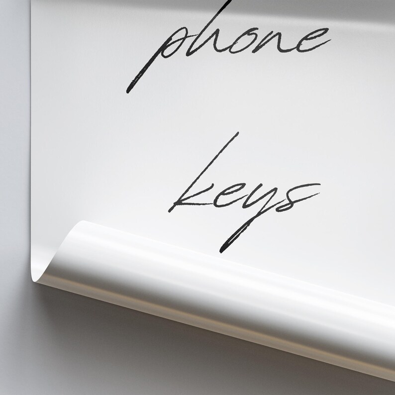 May include: A white sheet of paper with the words "phone" and "keys" written on it in black ink.