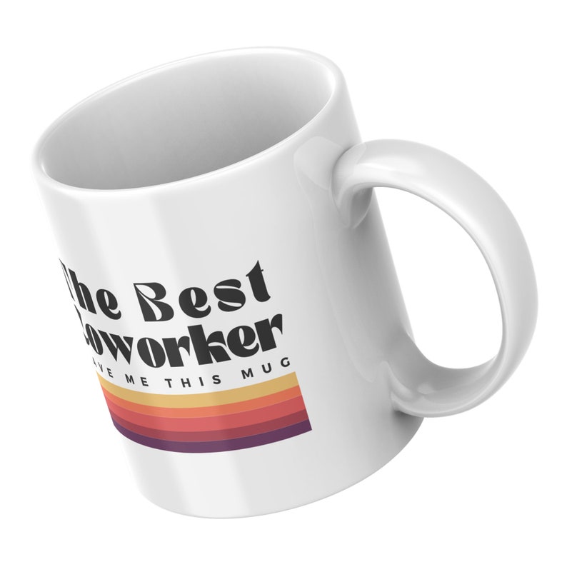 May include: White ceramic mug with black text that reads "The Best Coworker Give Me This Mug" with a retro-style rainbow stripe design.