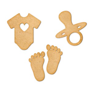 May include: Three wooden cutouts in the shape of a baby onesie, a pacifier, and two baby feet. The onesie has a heart cutout in the center. The pacifier has a ring handle. The feet are simple outlines.