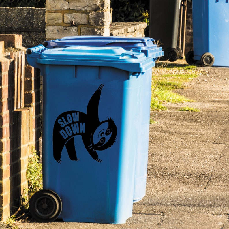 May include: Blue recycling bin with a black sloth sticker that says "Slow Down".