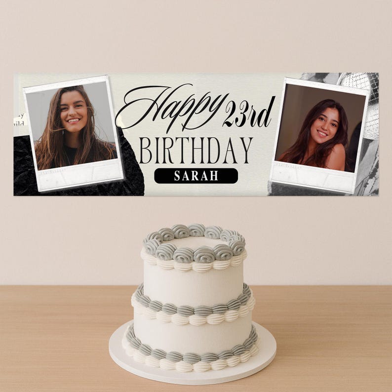 Op de afbeelding: Een witte verjaardagstaart met twee lagen en grijze glazuuraccenten staat op een houten tafel. Boven de taart staat een banner met de tekst "Happy 23rd Birthday Sarah" en twee ingelijste foto's van een vrouw.