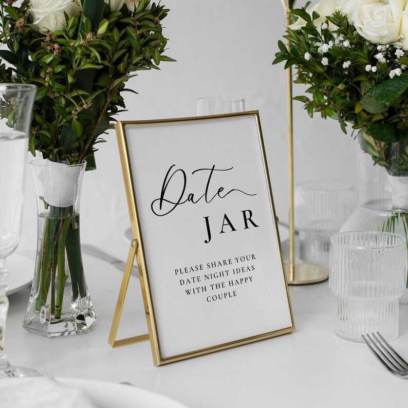 May include: Gold-framed sign with the text "Date JAR" and the message "Please share your date night ideas with the happy couple".