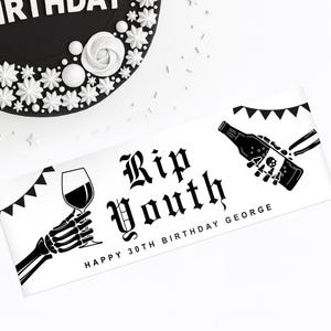 May include: A black and white banner with the text "Rip Youth" in gothic font, flanked by skeleton hands holding a wine glass and a bottle with a skull. The banner reads "Happy 30th Birthday George". A black cake with white decorations is in the background.
