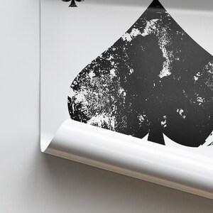 Puede incluir: Una imagen en blanco y negro de una carta de juego con un palo de picas. La pica es un dise&ntilde;o desgastado con un fondo blanco.