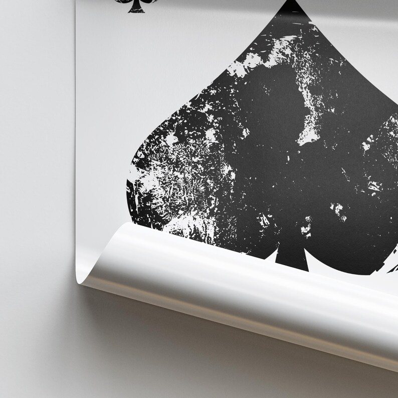 Puede incluir: Una imagen en blanco y negro de una carta de juego con un palo de picas. La pica es un dise&ntilde;o desgastado con un fondo blanco.