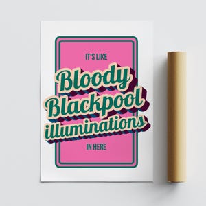 以下が含まれることがあります： 「IT'S LIKE Bloody Blackpool illuminations IN HERE」のテキストがレトロなフォントで書かれたピンク色の長方形がある白いポスター。ポスターの隣には、丸められた茶色のポスターがあります。