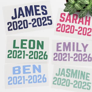 May include: Six personalized name and year stickers with glitter. The stickers are in various colors, including blue, green, pink, purple, and teal. The names are James, Sarah, Leon, Emily, Ben, and Jasmine. The years are 2020-2025, 2020-2022, 2021-2026, 2021-2026, 2021-2026, and 2020-2025.