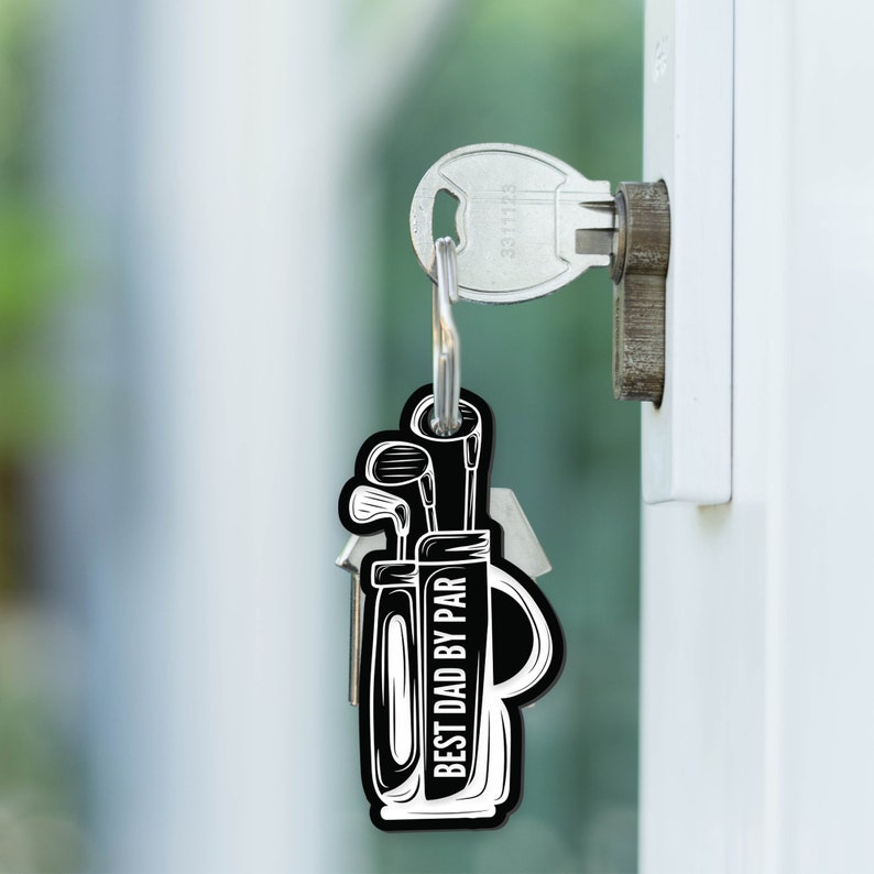 May include: Black and white keychain with a golf bag design and the text "Best Dad By Par".