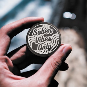 May include: A black and white round sticker with the text "Sober Vibes Only" in a white, stylized font.