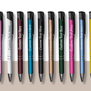 May include: Ten personalized pens in various colors, including pink, white, burgundy, blue, black, gold, green, magenta, light blue, and yellow. Each pen has the text "Custom Text Here" engraved on the side.