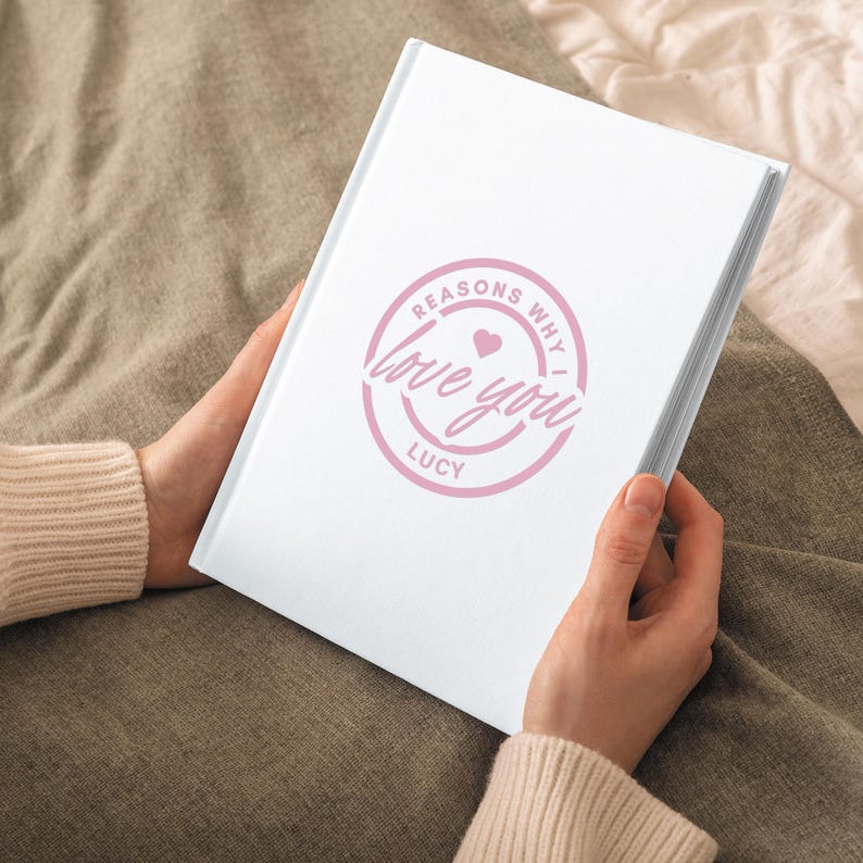 May include: A white journal with a pink circle on the cover that says "Reasons Why I Love You Lucy" with a small pink heart.
