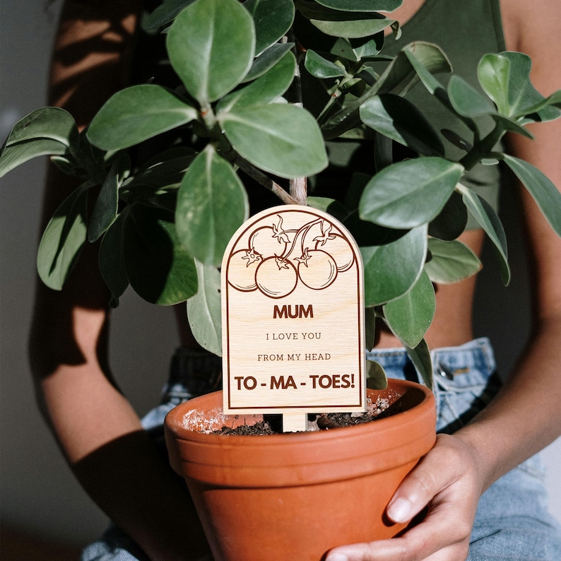 May include: Wooden plant marker with a brown stain and a cute design of tomatoes. The marker says "Mum I love you from my head to-ma-toes!"
