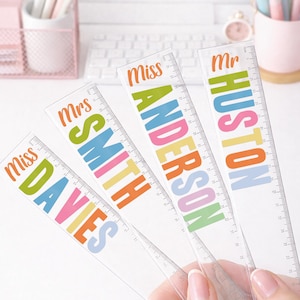 Puede incluir: Reglas de pl&aacute;stico transparente con texto colorido. Las reglas est&aacute;n personalizadas con nombres como "Miss Davies", "Mrs Smith", "Miss Anderson" y "Mr Huston". Cada regla tiene una escala de medici&oacute;n impresa en cent&iacute;metros.
