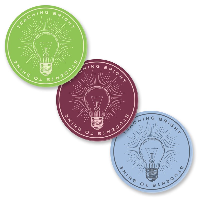 May include: Three round stickers with a light bulb graphic and the text "Teaching Bright Students to Shine". The stickers are green, maroon, and blue.