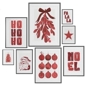 Puede incluir: Una colecci&oacute;n de l&aacute;minas art&iacute;sticas navide&ntilde;as enmarcadas. Las l&aacute;minas presentan dise&ntilde;os rojos festivos sobre fondos blancos, incluyendo mu&eacute;rdago, adornos, una estrella y las palabras "HO HO HO", "NOEL" y "FA LA LA".