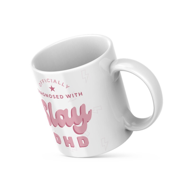 May include: White ceramic mug with a pink graphic that says "Officially Diagnosed with Slay ADHD".