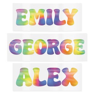 May include: Three white rectangular stickers with names in a colorful tie-dye font. The names are "EMILY", "GEORGE", and "ALEX". The letters are in a bubble style with a watercolor effect, featuring shades of blue, yellow, orange, and purple.