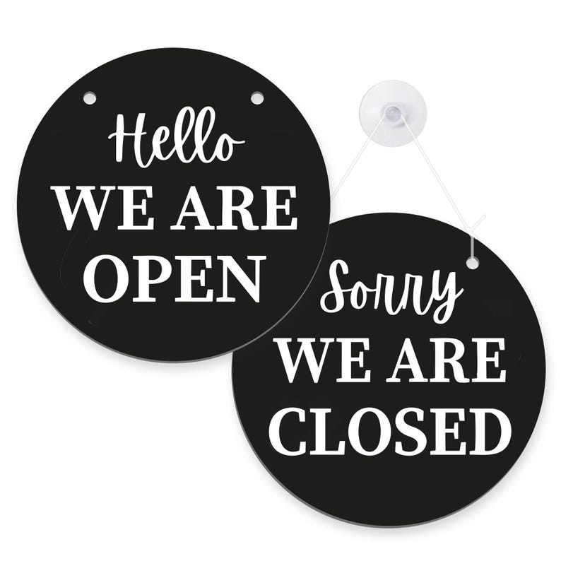 K&ouml;nnte beinhalten: Zwei schwarze, runde Schilder mit wei&szlig;em Text. Eines sagt "Hello WE ARE OPEN", das andere sagt "Sorry WE ARE CLOSED". Die Schilder sind durch eine wei&szlig;e Schnur und einen Saugnapf verbunden.