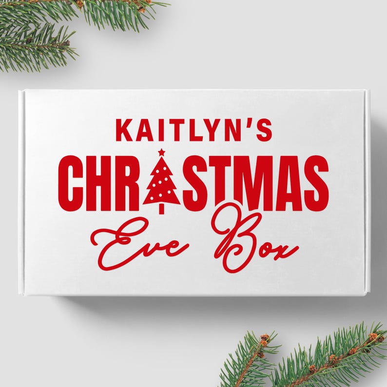 May include: White box with red text that reads "Kaitlyn's Christmas Eve Box". A red Christmas tree icon is above the word "Christmas".