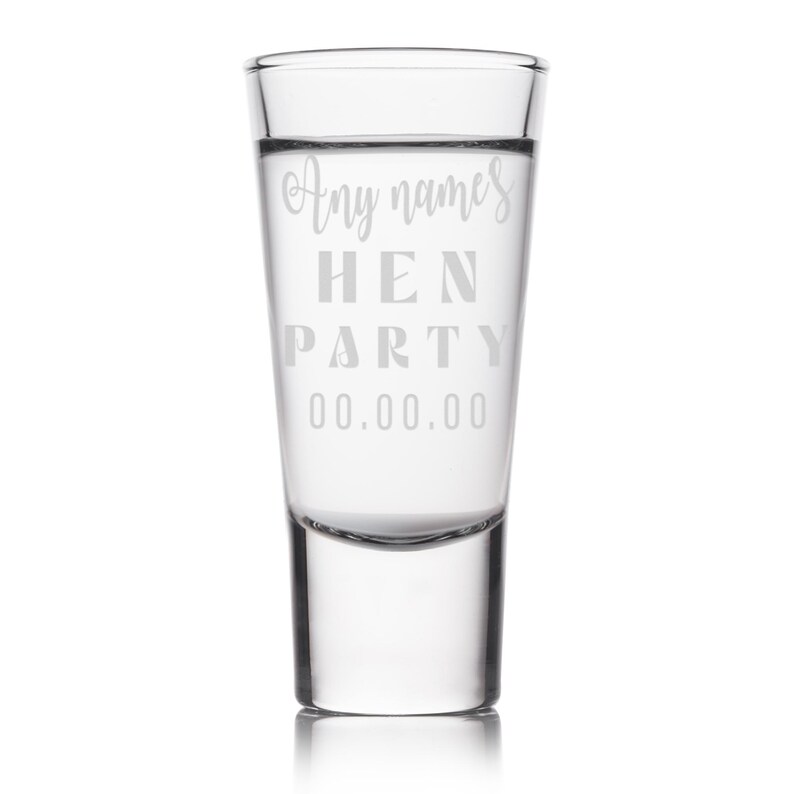 Op de afbeelding: Een helder shotglaasje met de woorden "Any names HEN PARTY 00.00.00" gegraveerd op de voorkant. Het glas is cilindrisch en heeft een dikke bodem. De tekst is in een licht, elegant lettertype.