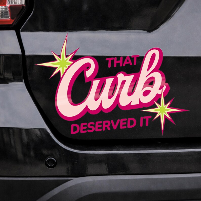 May include: A car decal with the text "That Curb Deserved It" in pink and white, with starburst accents. The decal is affixed to a black vehicle.