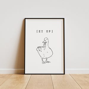 May include: Black and white line art print of a duck with the text "[EY UP]" in a black frame.