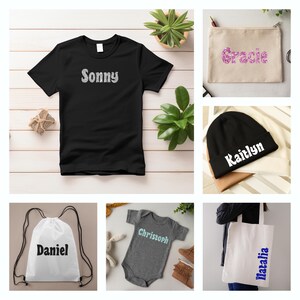 May include: A collection of personalized items featuring various names, including Sonny, Gracie, Kaitlyn, Daniel, Christoph, and Natalia. The items include a black t-shirt, a beige canvas pouch, a black beanie, a white drawstring bag, a gray baby onesie, and a white tote bag.
