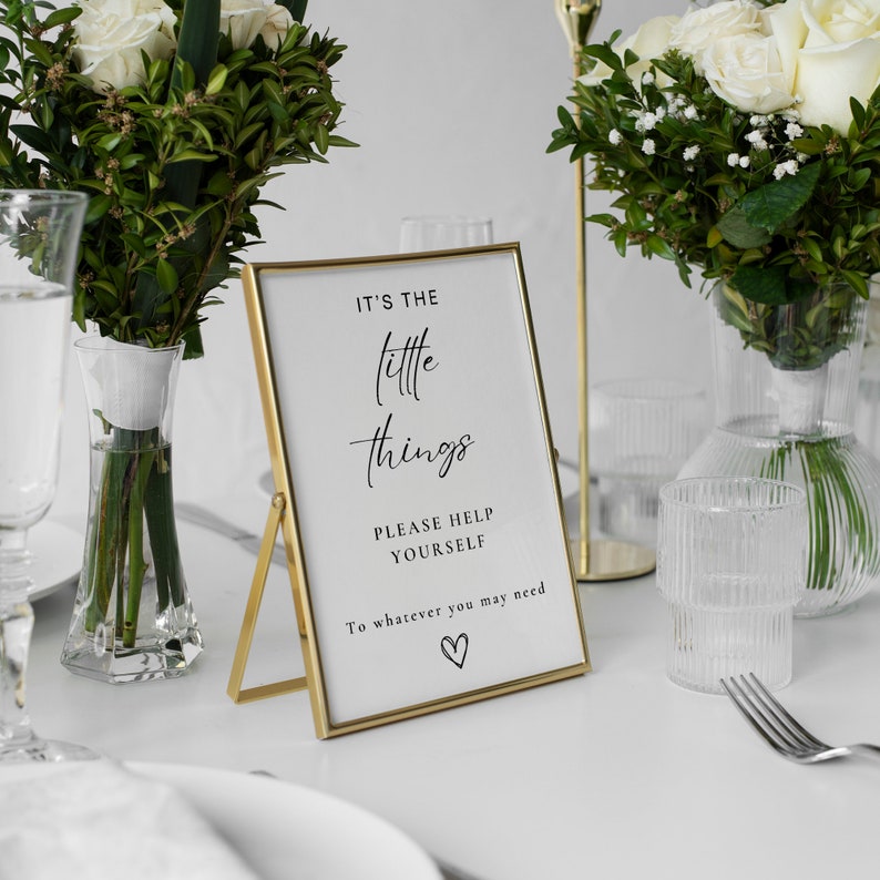 May include: Gold framed sign with the text "It's the little things. Please help yourself to whatever you may need." with a small heart symbol at the bottom.