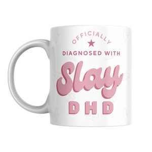 May include: White ceramic mug with a pink design that says "Officially Diagnosed with Slay DHD".