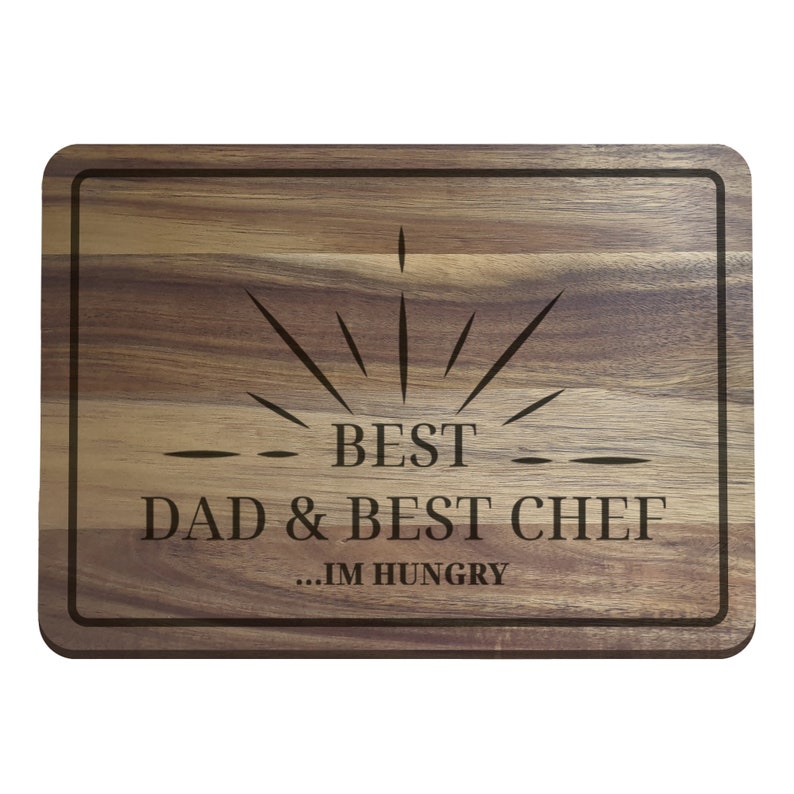 Puede incluir: Una tabla de cortar de madera con el texto "BEST DAD & BEST CHEF...IM HUNGRY" grabado en ella.