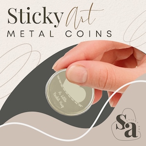 May include: A silver metal coin with the words "A little Pocket Hug" engraved on it. The coin is being held by a hand against a brown and beige background with the words "Sticky Art METAL COINS" at the top.