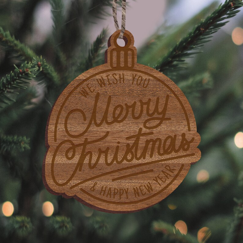 May include: A wooden Christmas ornament shaped like a bell with the text "We wish you Merry Christmas & Happy New Year" engraved on it.