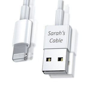 Op de afbeelding: Witte iPhone-oplaadkabel met een USB-connector. De USB-connector heeft de tekst "Sarah's Cable" erop gedrukt.
