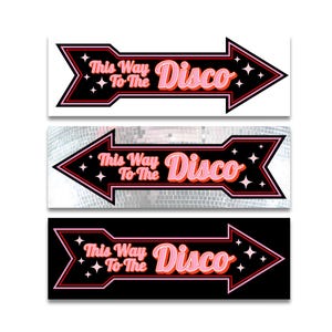 Pu&ograve; includere: Tre cartelli a forma di freccia con la scritta "This Way To The Disco" in rosa e arancione, bordati di nero e rosso. I cartelli hanno un design retr&ograve; con accenti di stelle e sono ambientati su sfondo bianco, palla da discoteca e nero.