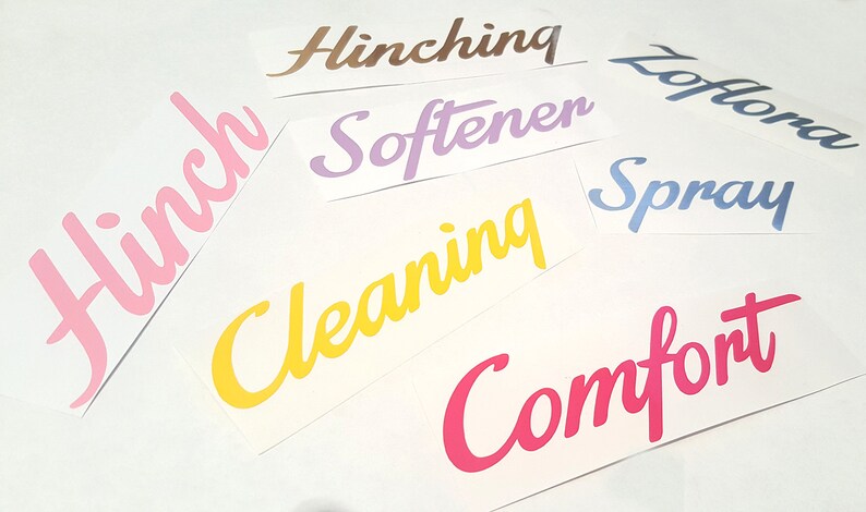 May include: Assortment of colorful vinyl lettering labels for home organization. The labels read "Hinch", "Cleaning", "Softener", "Spray", "Comfort", "Hinch", and "Loft" in a variety of colors.