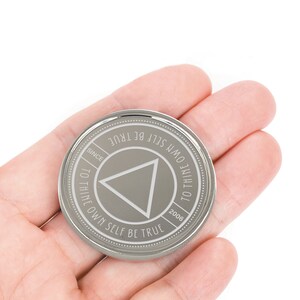 May include: A silver coin with the inscription "To thine own self be true" and a triangle in the center. The coin also has the inscription "Since 2006".