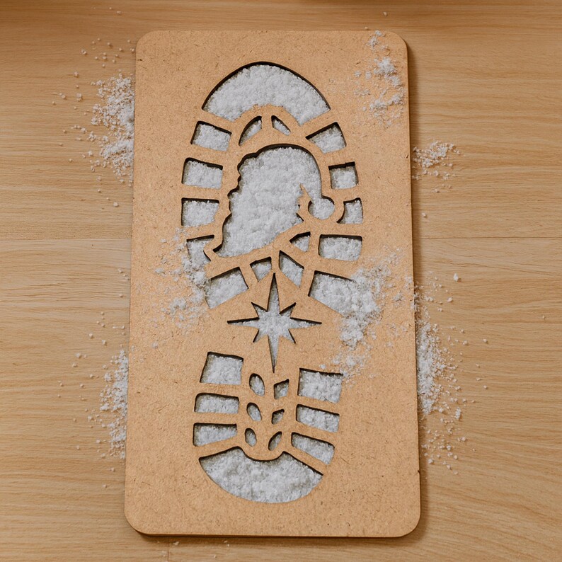 May include: A rectangular, light brown wooden stencil in the shape of a boot print, filled with white material. The stencil features a star and a silhouette of Santa Claus. The background is a light brown wooden surface.